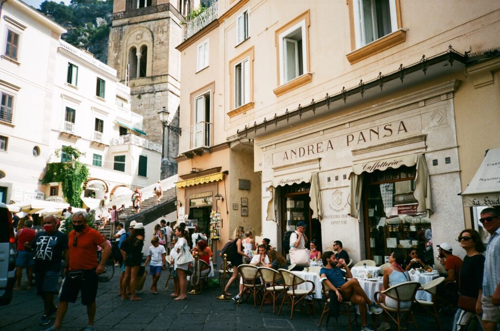 a group of people sitting at tables in front of a building